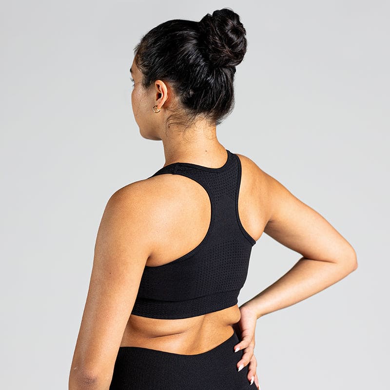 Soft Flow Yoga Bra in Schwarz; nahtloser Sport BH mit Racerback und Mesh-Details für Belüftung bei Yoga, Pilates und low-impact Training.