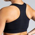 Soft Flow Yoga Bra in Schwarz; nahtloser Sport BH mit Racerback und Mesh-Details für Belüftung bei Yoga, Pilates und low-impact Training.