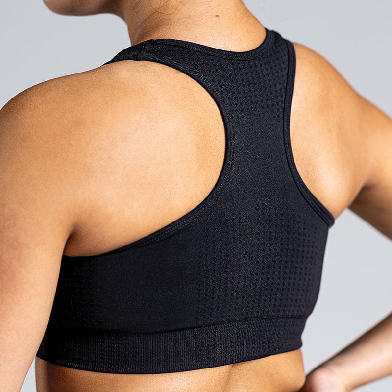 Soft Flow Yoga Bra in Schwarz; nahtloser Sport BH mit Racerback und Mesh-Details für Belüftung bei Yoga, Pilates und low-impact Training.